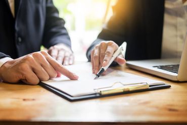 Zwei Personen zeigen auf ein Dokument