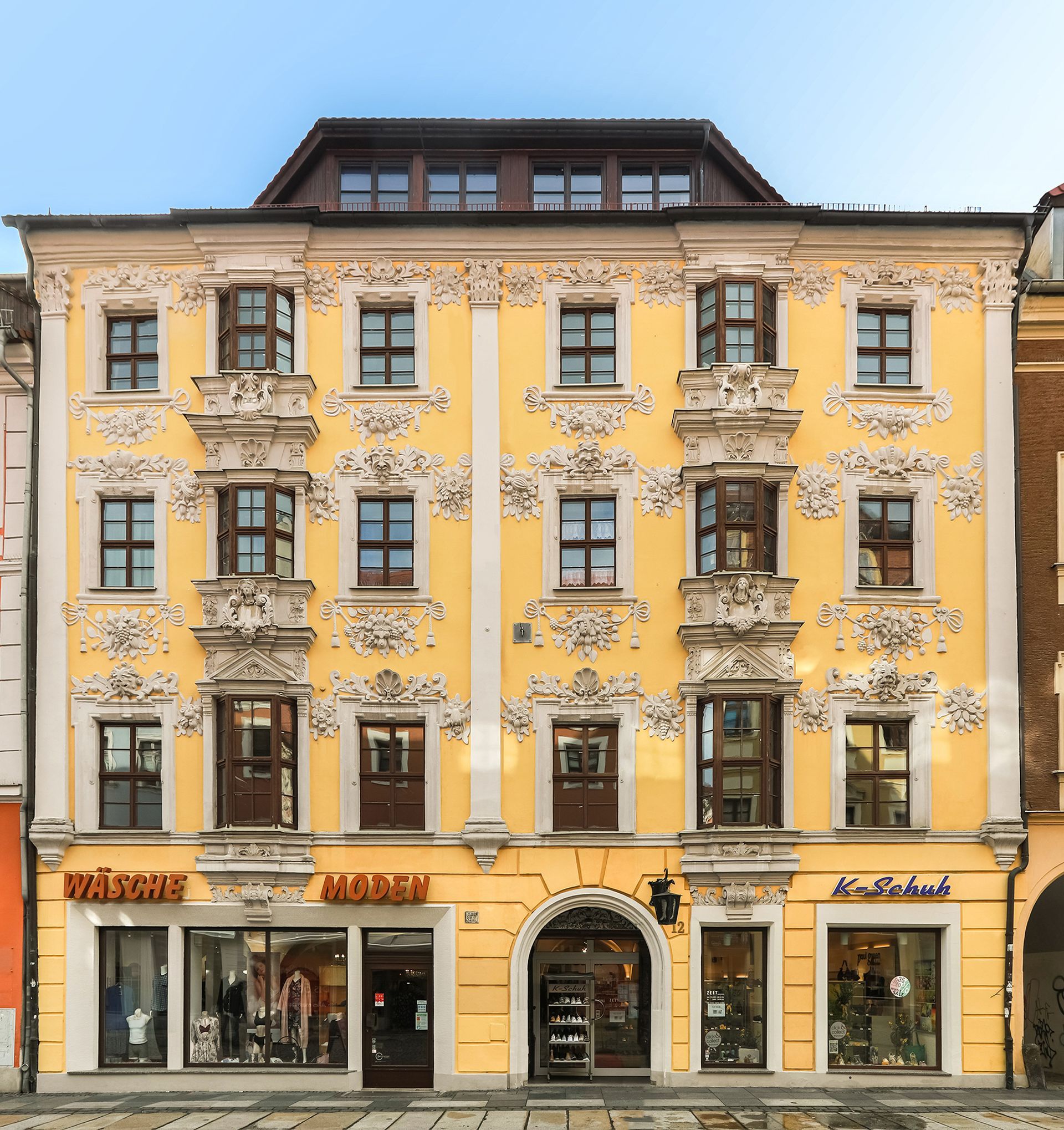 Historisches Gebäude in Gelb, mit Stuck verziert