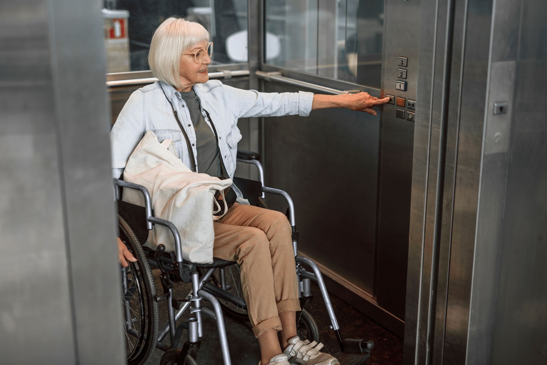 Femme agée en fauteuil dans l'ascenseur