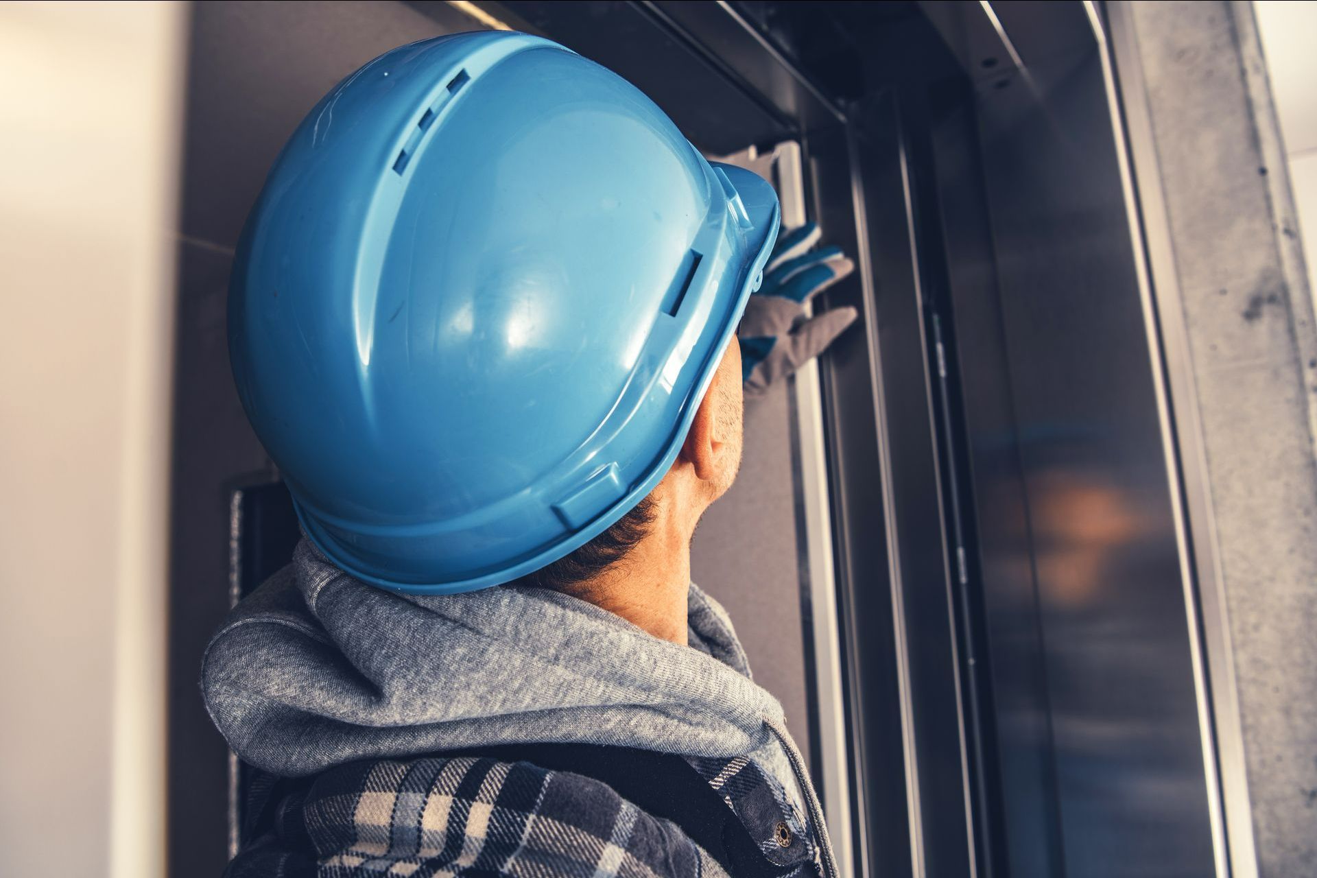Ascensoriste avec un casque bleu analysant un ascenseur