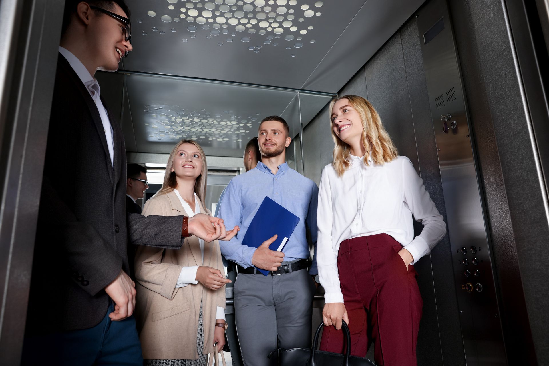 Équipe de salariés discutant dans un ascenseur