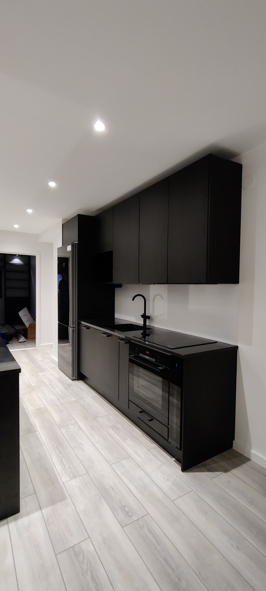 Uudistava oy keittiöremontti musta minimalistinen keittiö keittiötaso integroidut keittiölaitteet