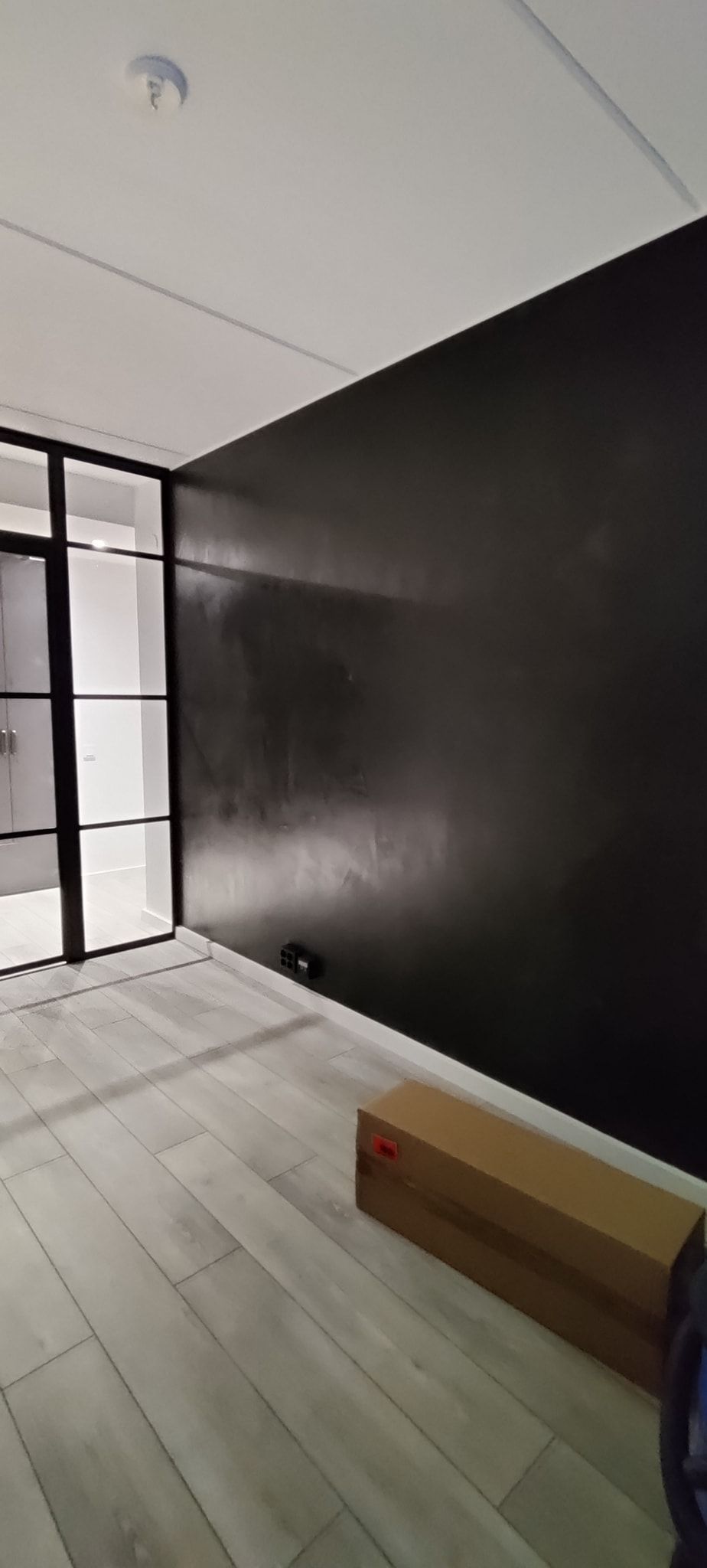 Uudistava huoneistoremontti lasiseinä musta seinä maalaaminen