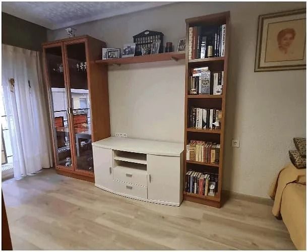 Una sala de estar con un mueble de televisión y estanterías.