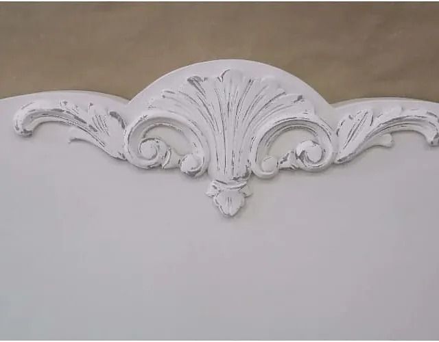 Un primer plano de una cabecera blanca con un diseño tallado.