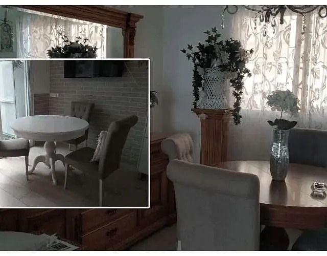Un comedor con una mesa y sillas y un jarrón con flores sobre la mesa.