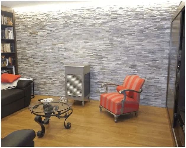 Una sala de estar con una pared de ladrillos y una silla roja.