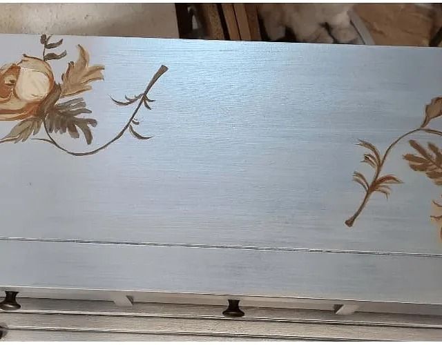 Un trozo de madera con flores pintadas en él.