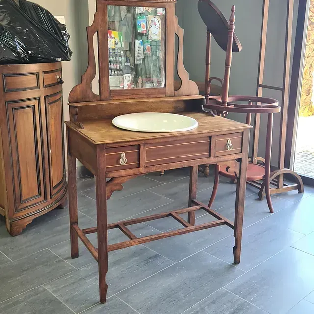 Un tocador de madera con lavabo y espejo.
