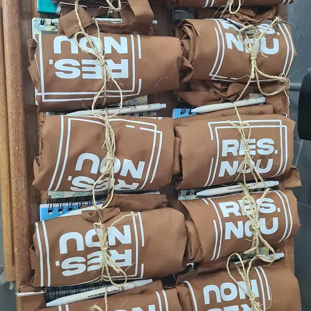 Una pila de camisas marrones con las palabras res nou en ellas