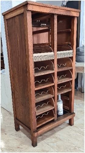 Un armario de madera con muchos estantes y una botella de jabón en el suelo.