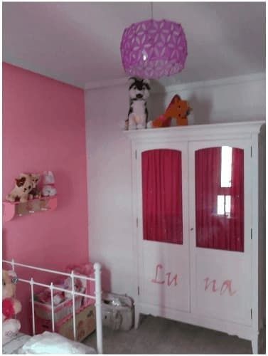 Un dormitorio con paredes rosas y un armario blanco con el nombre Luna.