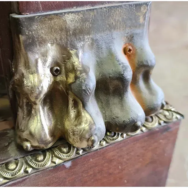 Un primer plano de una escultura de latón sobre una superficie de madera.