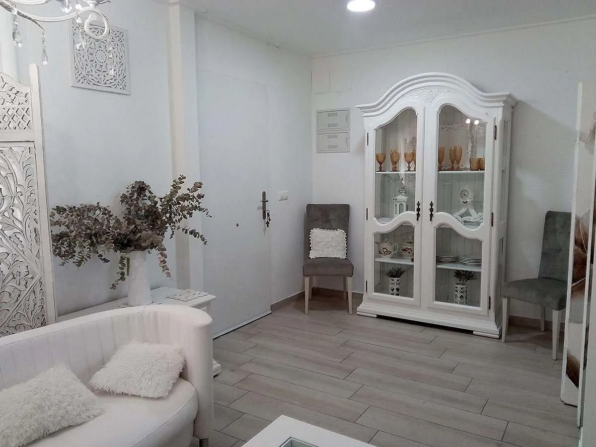 Una sala de estar con un sofá, una silla y una vitrina.