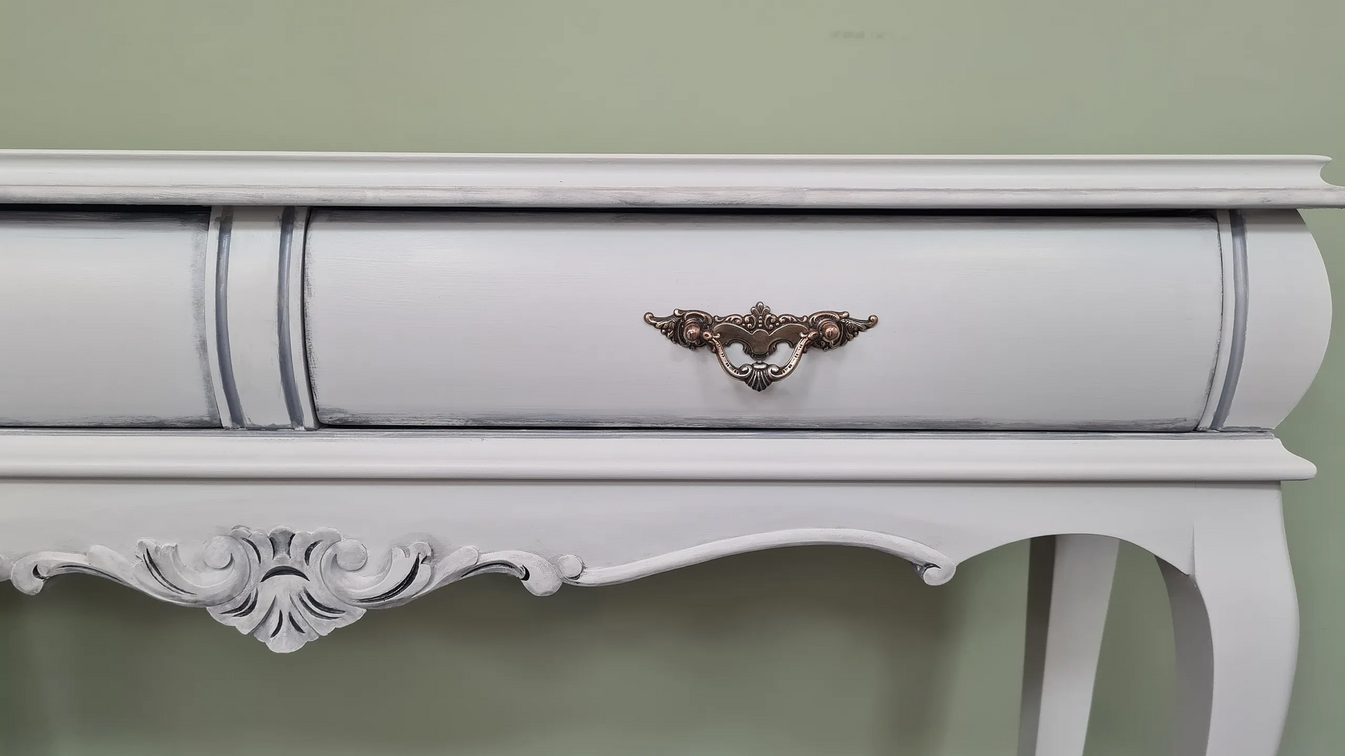 Un primer plano de una mesa blanca con un cajón encima.