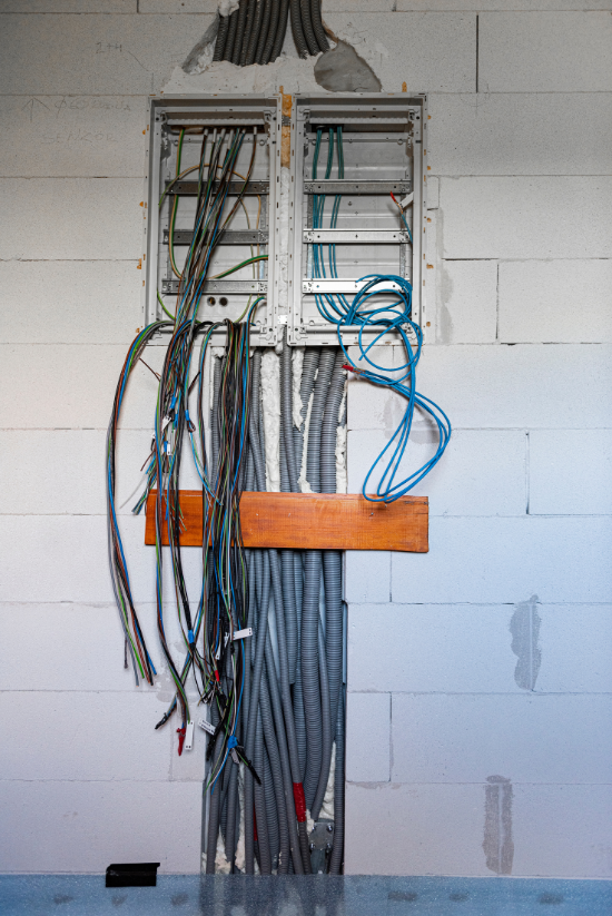 Câblage électrique et conduit sortant du mur, boîte de jonction ouverte.