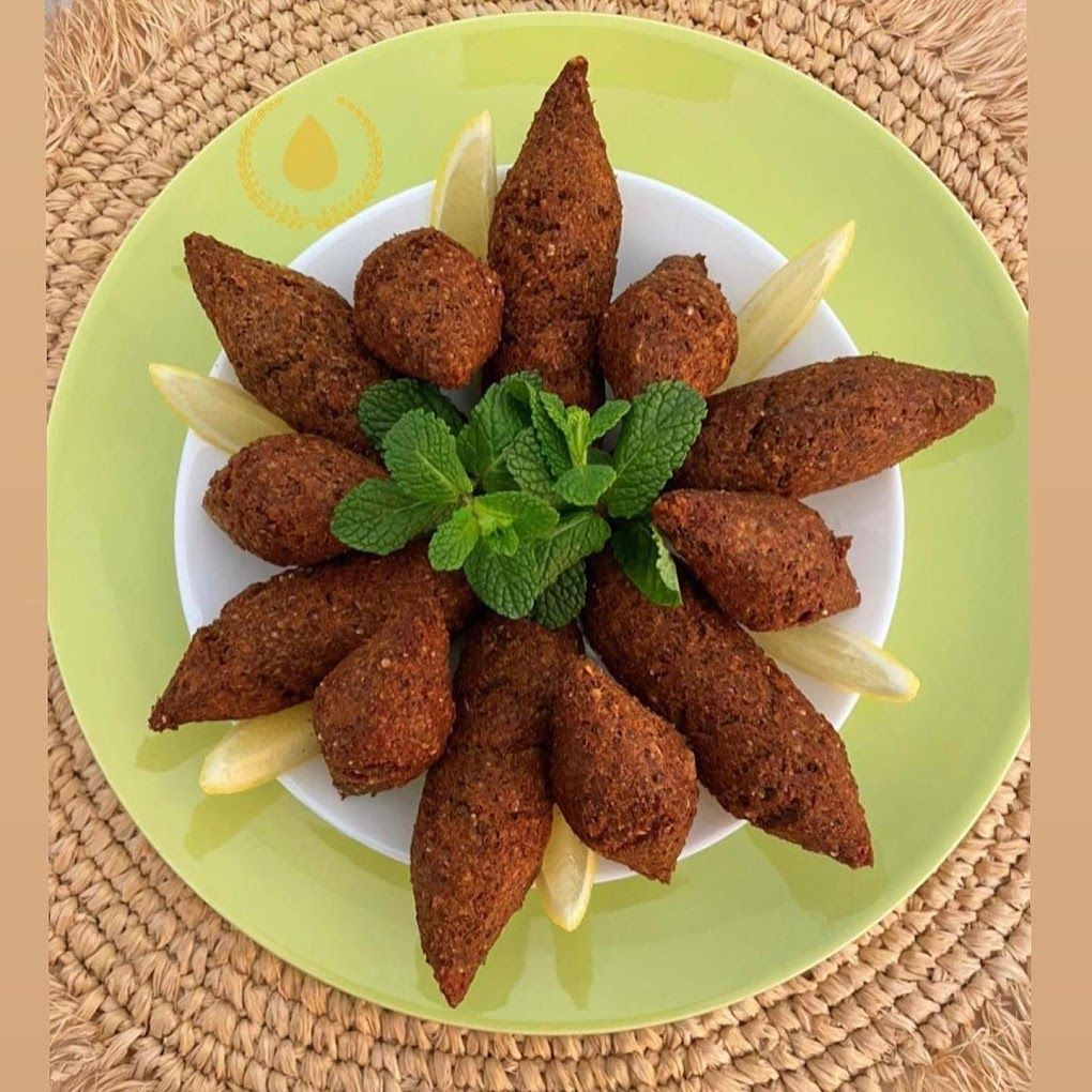 Un plato verde cubierto con albóndigas y hojas de menta.