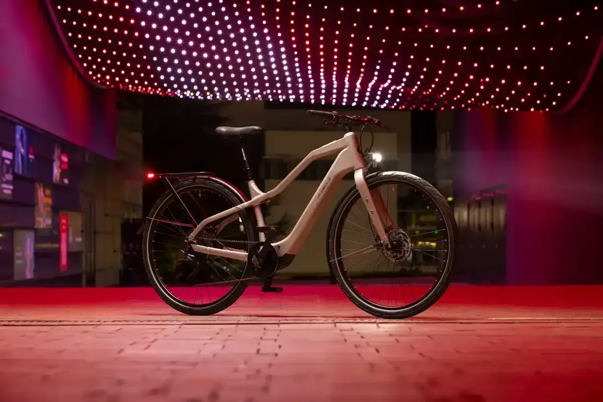 Bicicleta de montaña expuesta en una sala de exposición con iluminación tenue de color rojo y techo resplandeciente.
