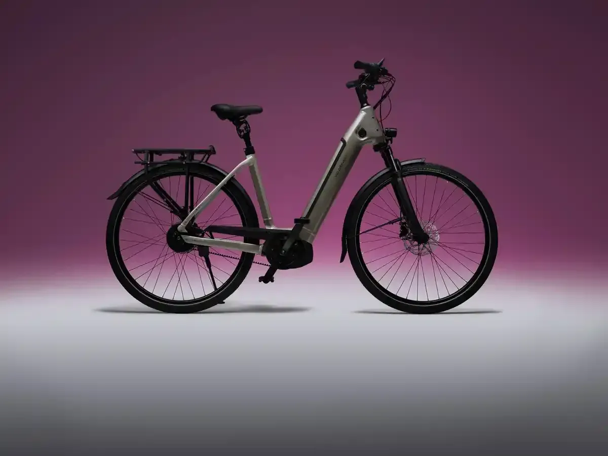 Bicicleta eléctrica negra sobre un fondo degradado rosa.