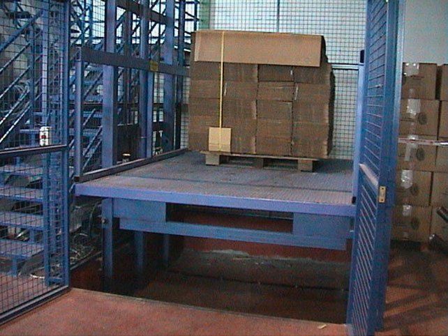 Una gran caja de cartón se encuentra encima de un palé en un almacén.