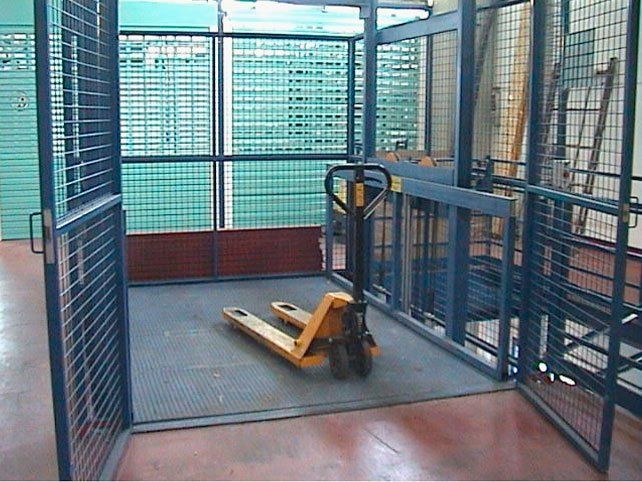 Una carretilla elevadora amarilla se encuentra dentro de una jaula.