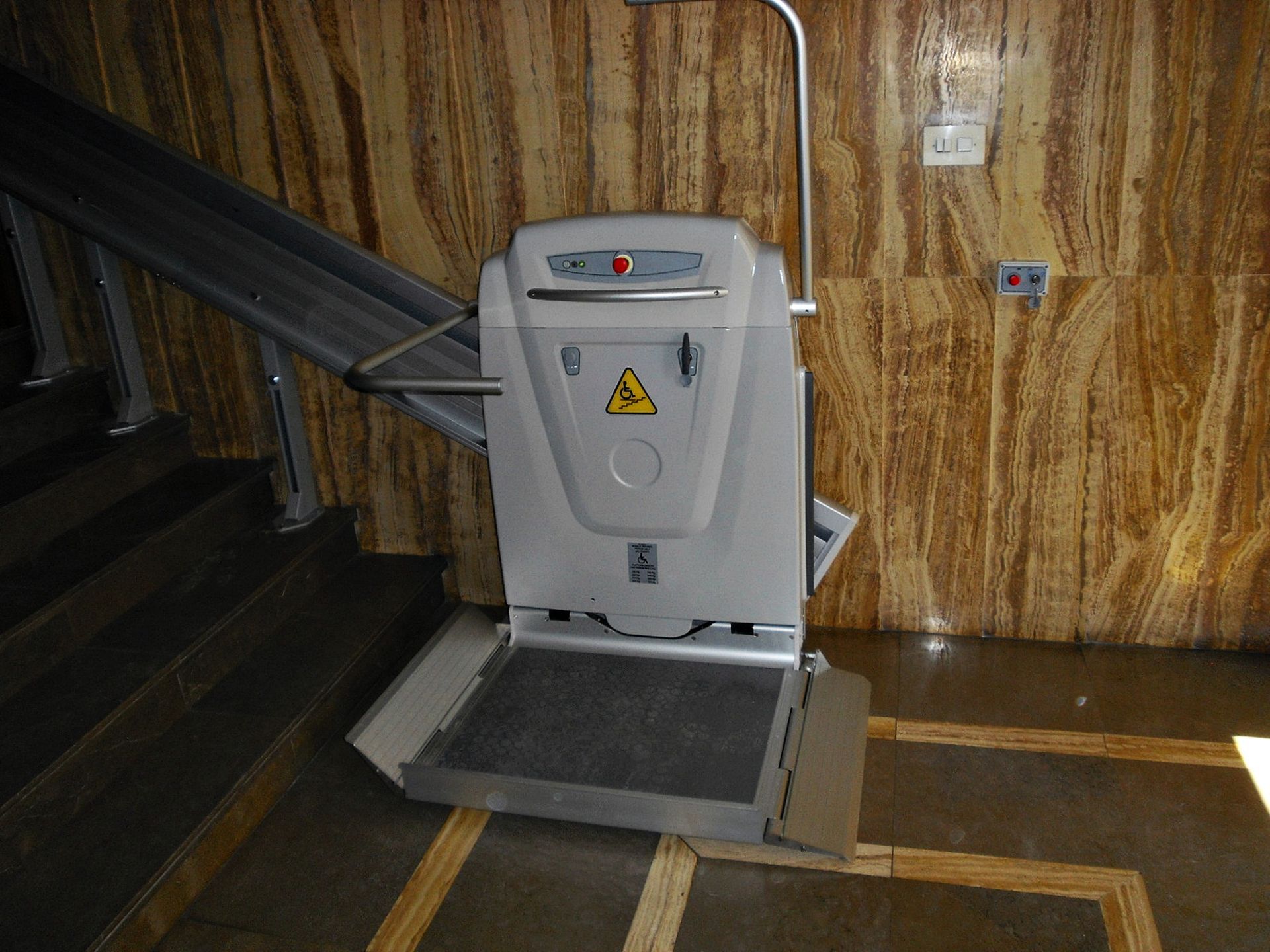 Un salvaescaleras está situado en una habitación al lado de una pared de madera.