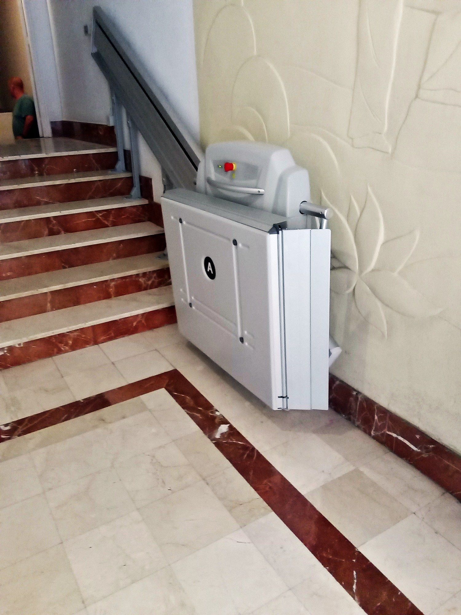 Hay un salvaescaleras en un pasillo junto a un conjunto de escaleras.