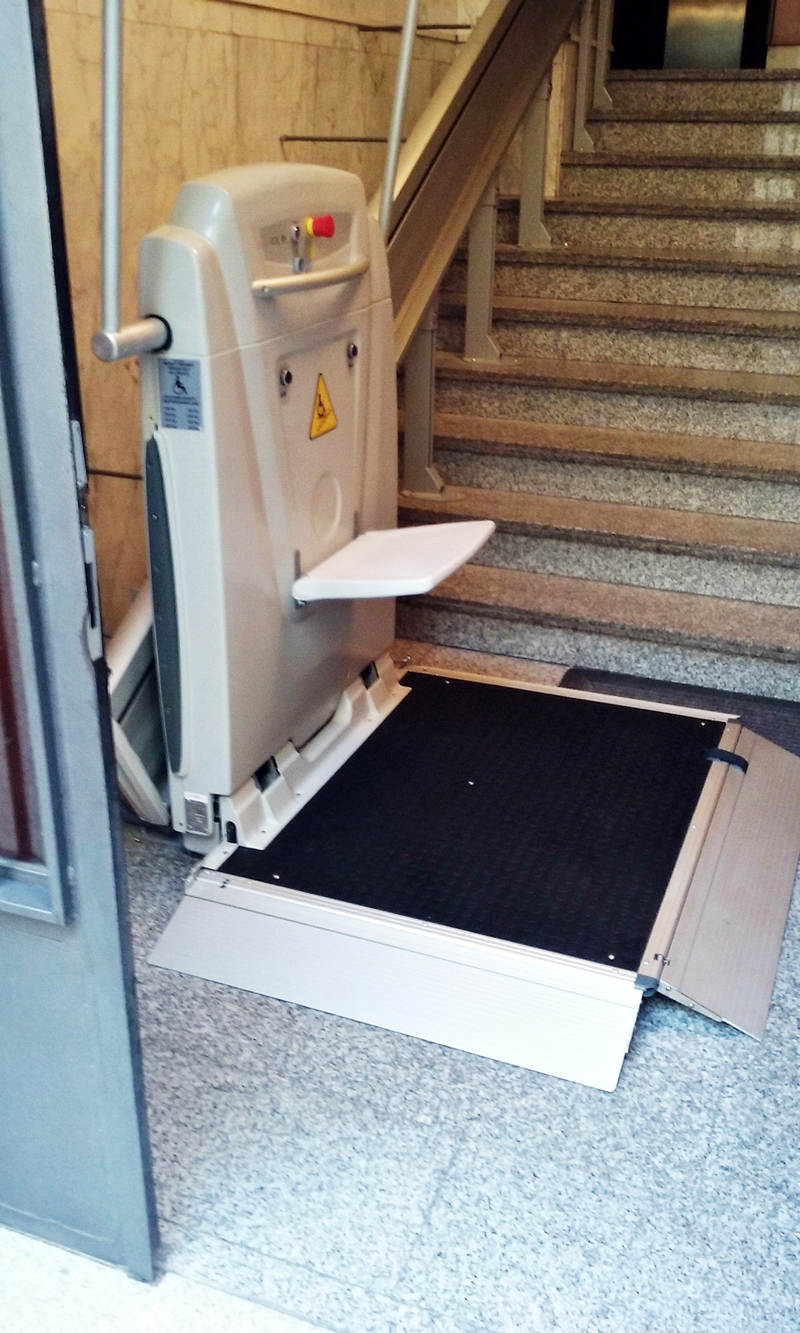 Un salvaescaleras se encuentra al lado de un conjunto de escaleras.