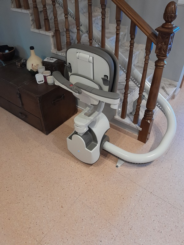 Una silla blanca está en el suelo al lado de una escalera.