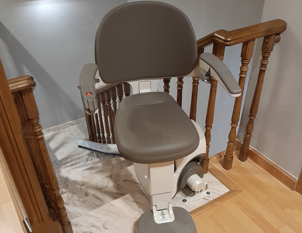 Una silla está encima de una escalera de madera.