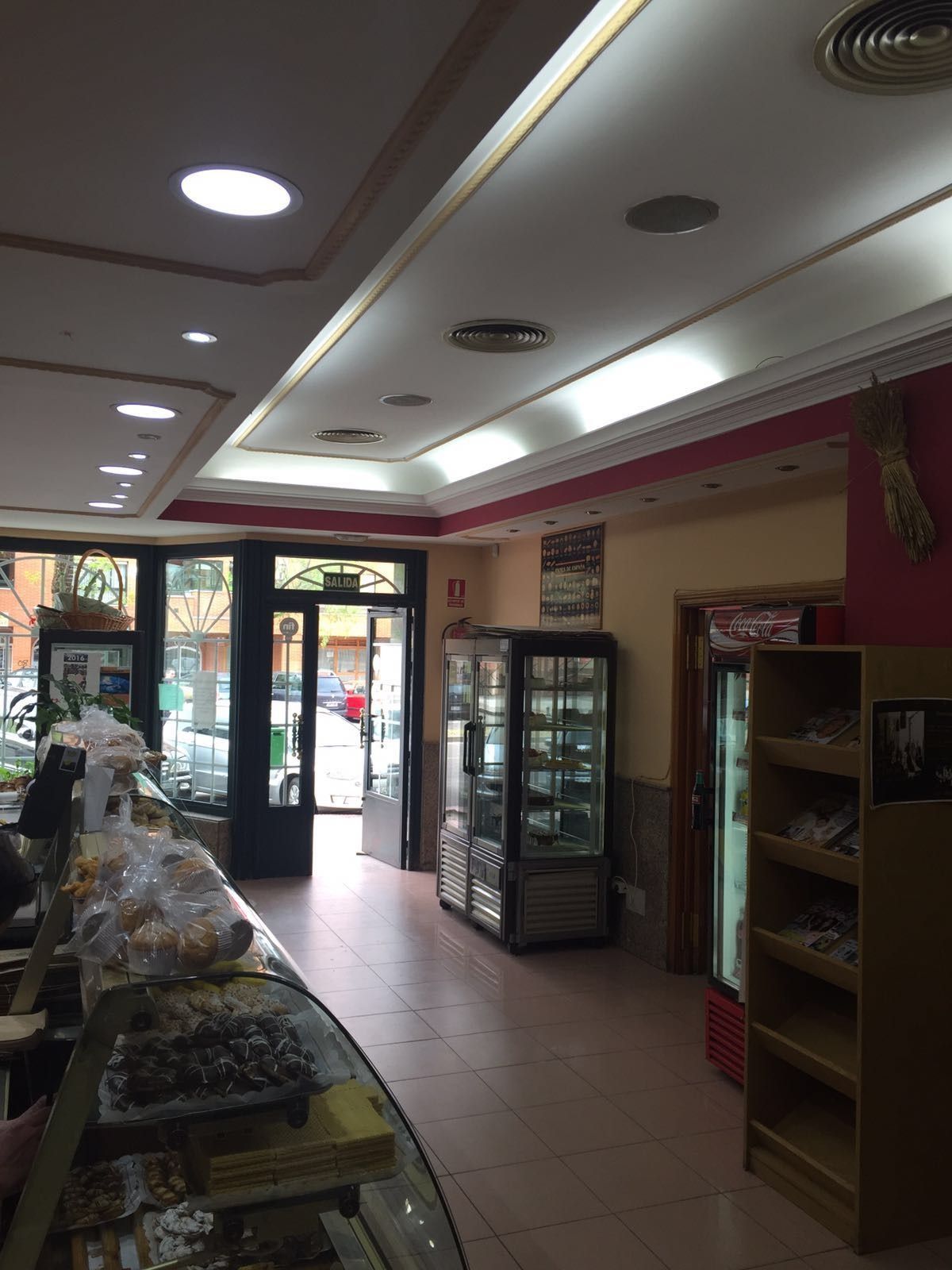 El interior de una panadería con una vitrina y un refrigerador.