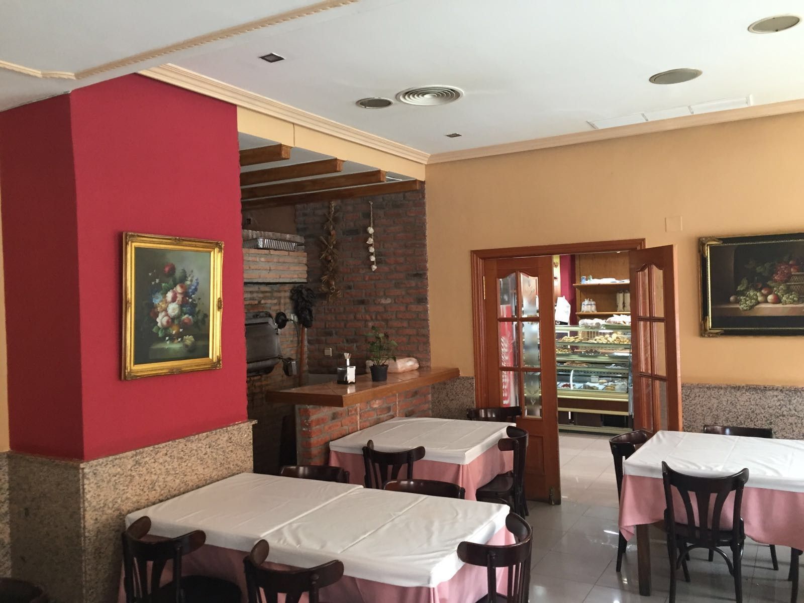 Un restaurante con mesas y sillas y un cuadro en la pared.