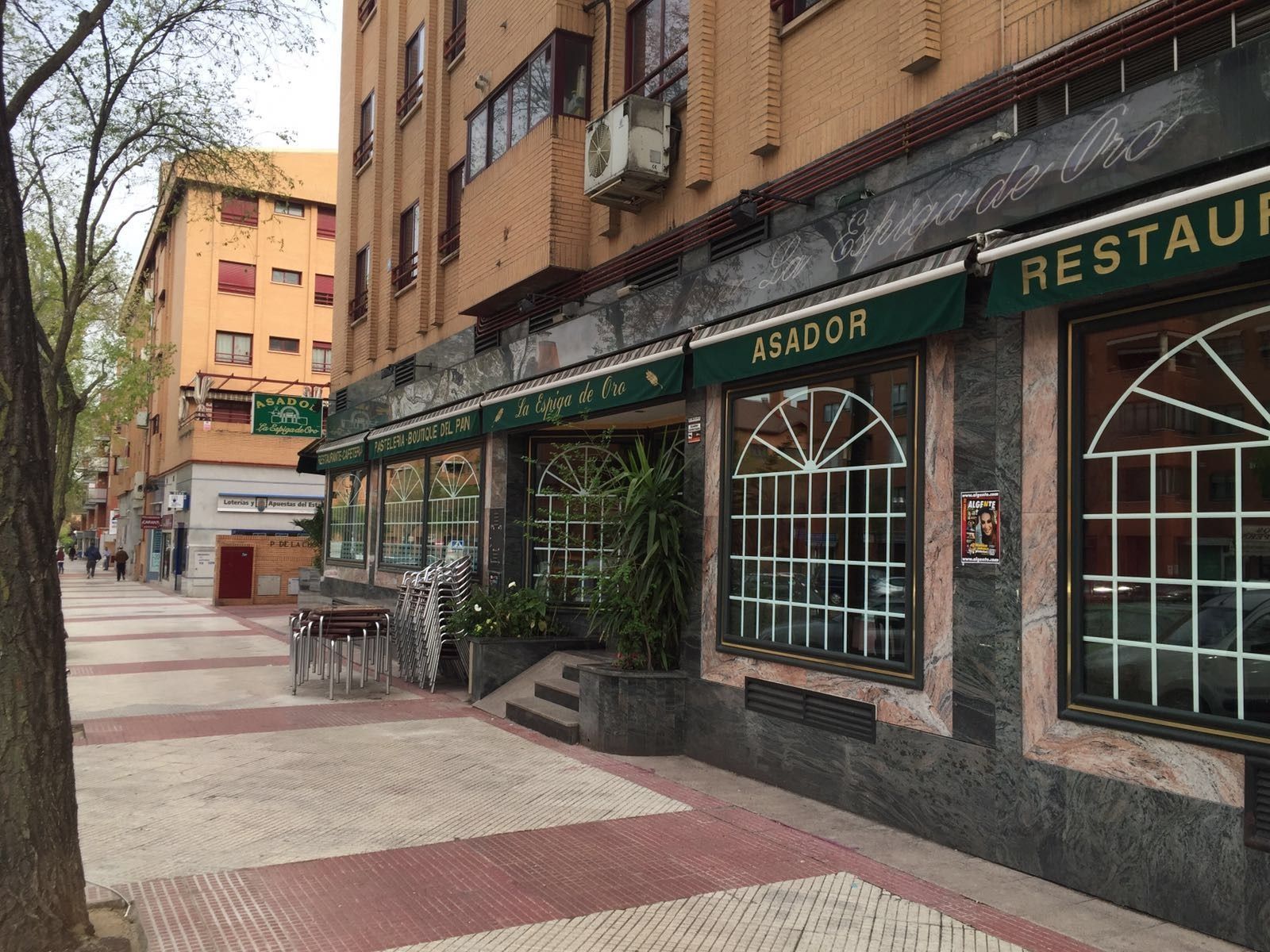 Un restaurante con un toldo verde al costado.