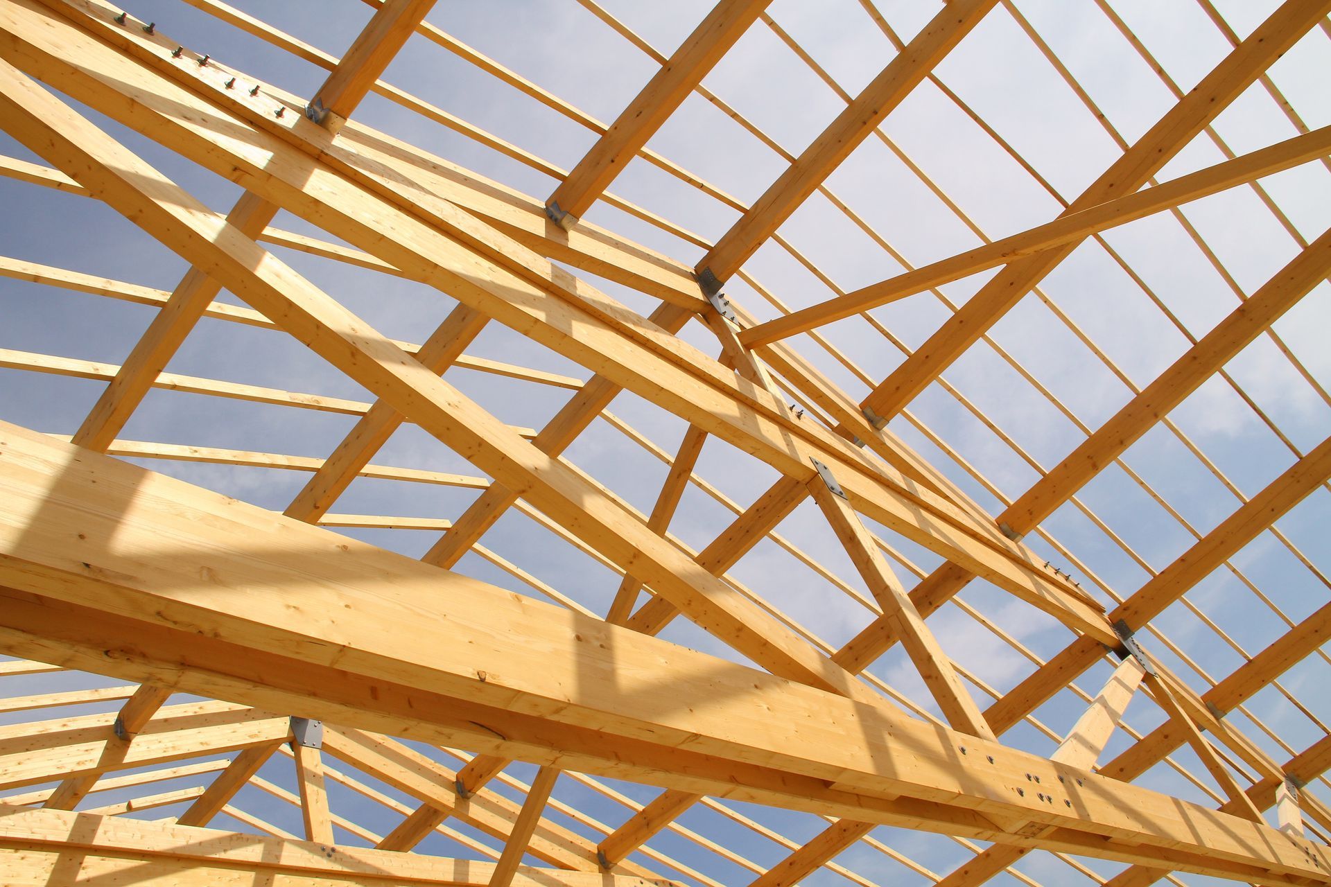 Charpente de toit en bois en construction sur fond de ciel bleu clair