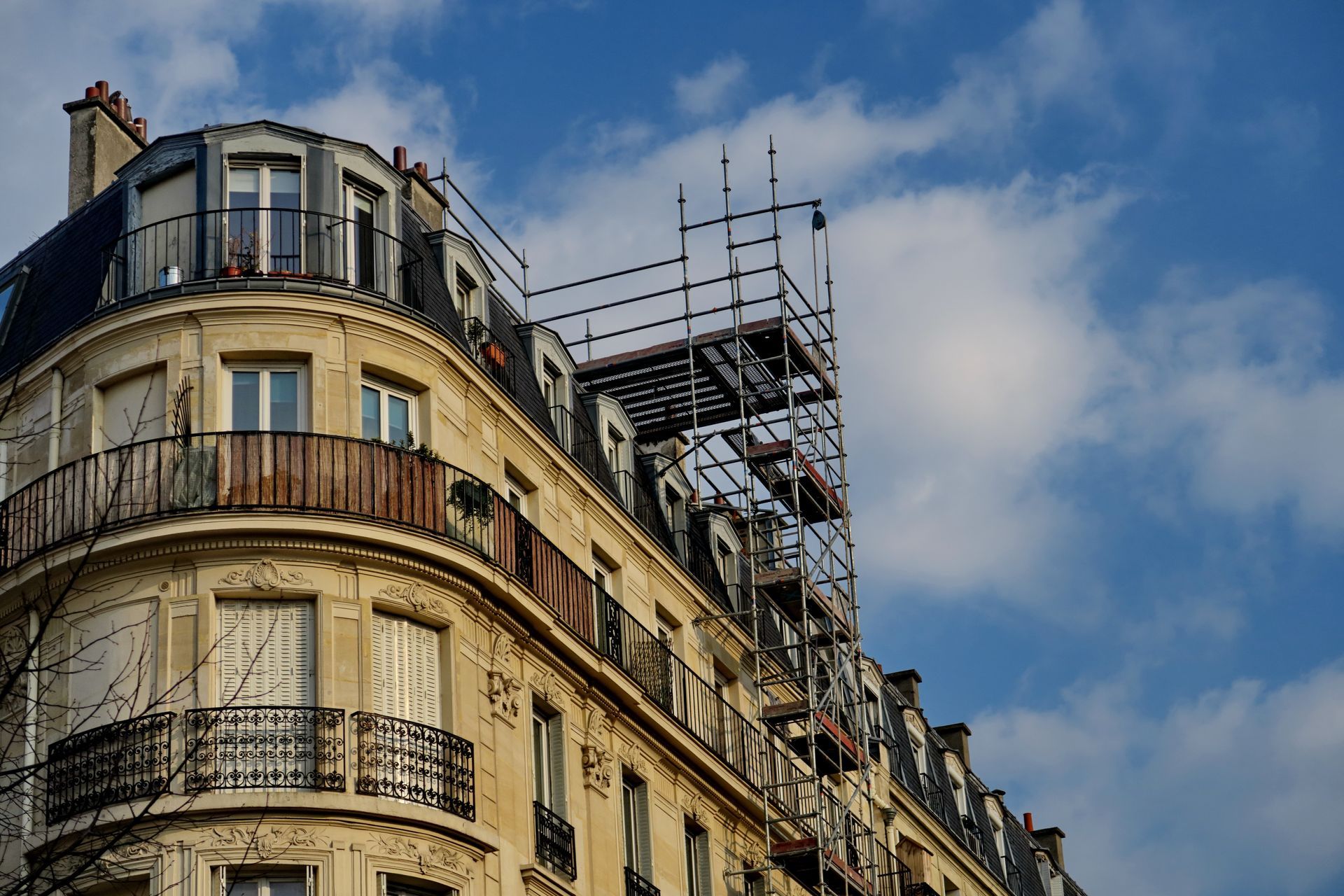 Immeuble d'appartements historique parisien avec des échafaudages sur fond de ciel bleu