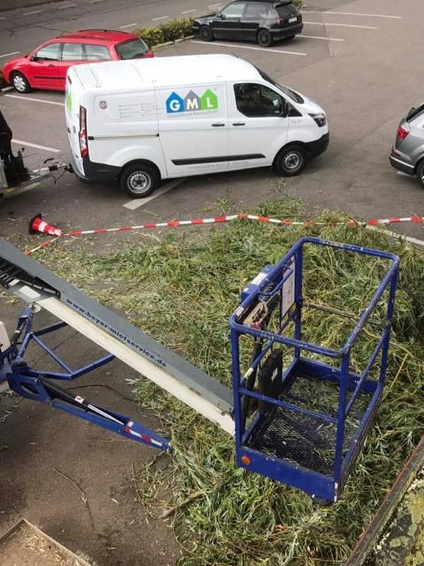 Ein weißer Lieferwagen steht auf einem Parkplatz neben einem Kran.