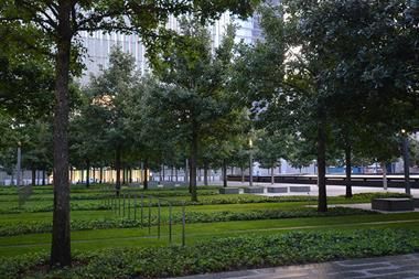 Ein Park mit vielen Bäumen und Gras und einem Gebäude im Hintergrund