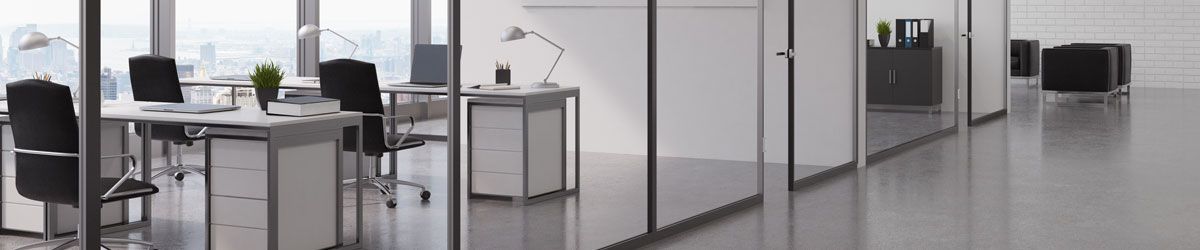 Ein langer Flur in einem Büro mit vielen Fenstern und Tischen und Stühlen.