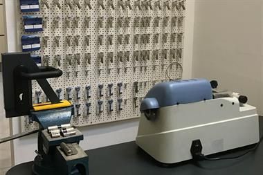 Eine Maschine steht auf einem Tisch vor einer Wand aus Tasten.