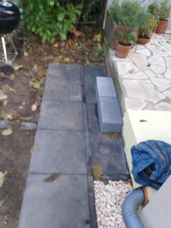 Eine Terrasse mit einem Grill und Topfpflanzen darauf