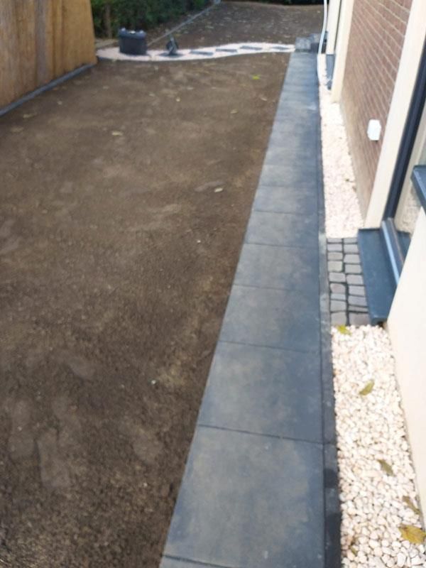 Ein Gehweg, der zu einem Rasen neben einem Haus führt.