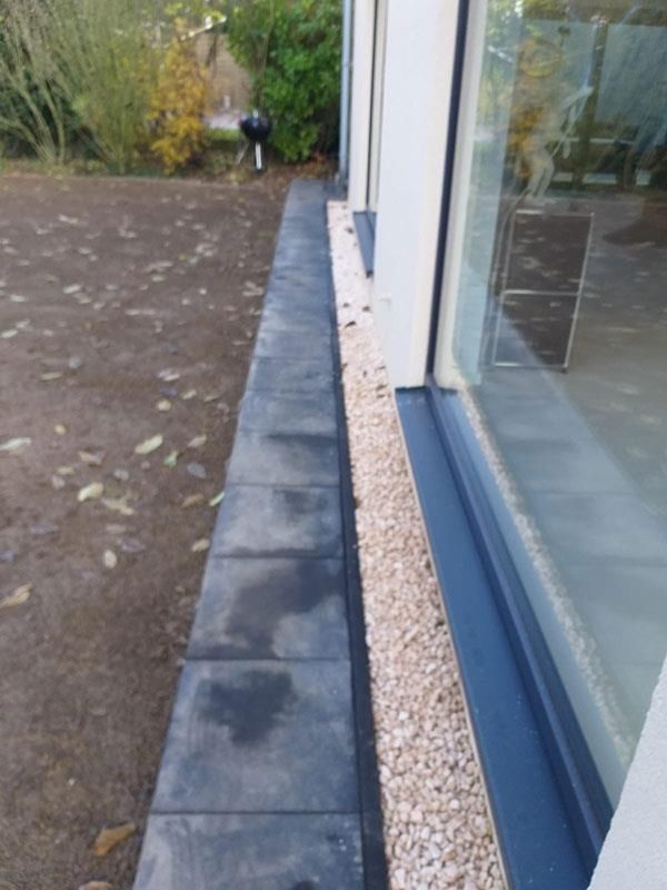 Ein Bürgersteig neben einem Gebäude mit einem Fenster