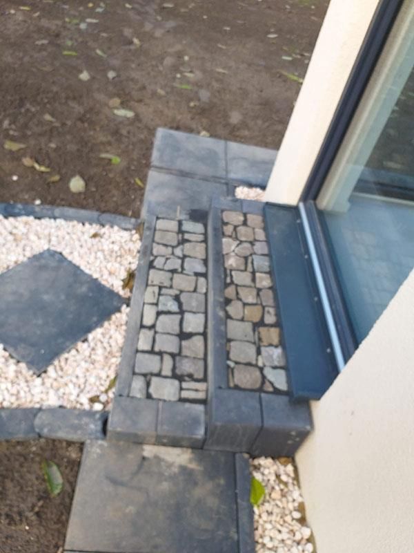 Ein Steinweg, der zu einem Haus mit einem Fenster führt