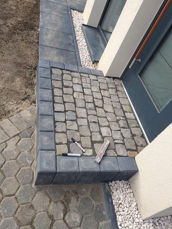 Ein gemauerter Gehweg neben einer Tür mit einer Markierung darauf