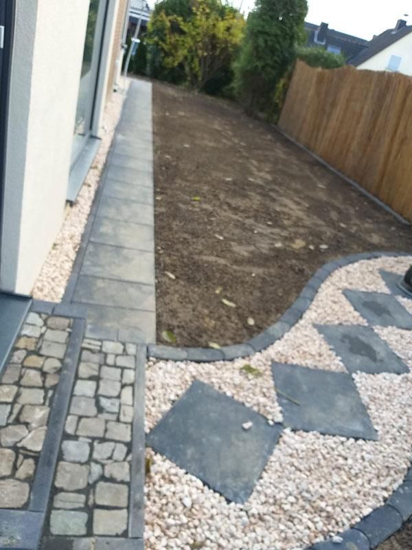 Ein Steinweg, der zu einem eingezäunten Hof führt