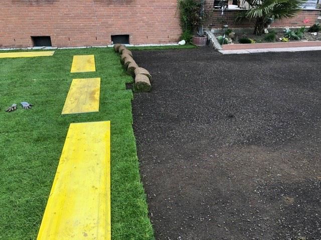 Ein Rasen mit einer gelben Linie und einem Backsteingebäude im Hintergrund