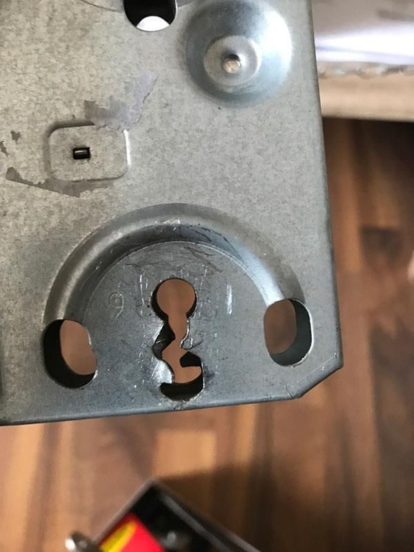 Eine Nahaufnahme eines Metallgegenstands mit Löchern auf einem Holzboden.