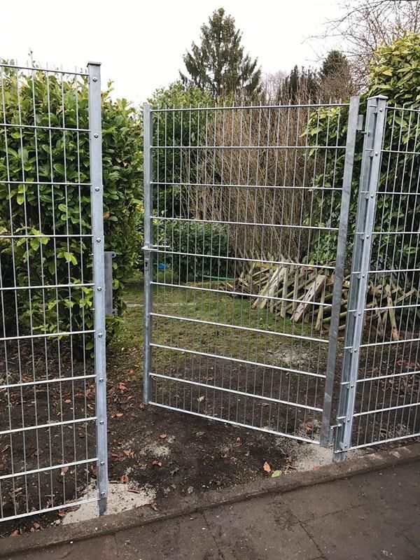 Ein Metallzaun mit einem offenen Tor