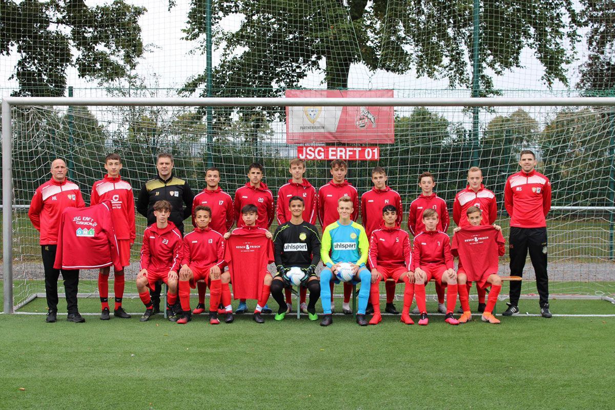 Eine Fußballmannschaft posiert auf einem Feld für ein Foto.