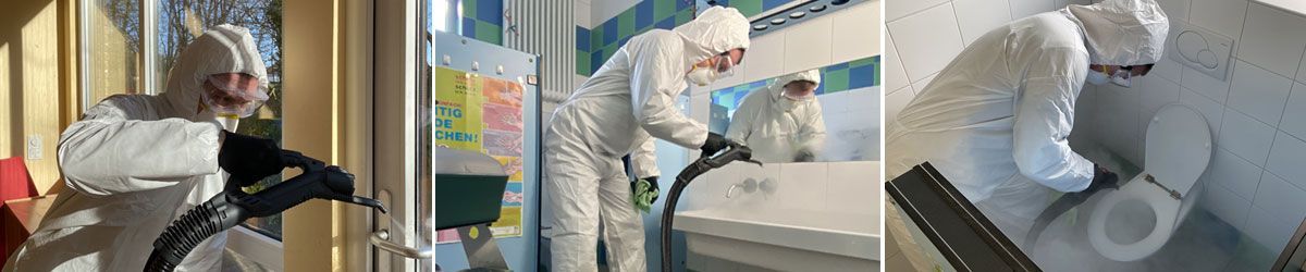 Ein Mann im Schutzanzug reinigt einen Raum mit einem Staubsauger.